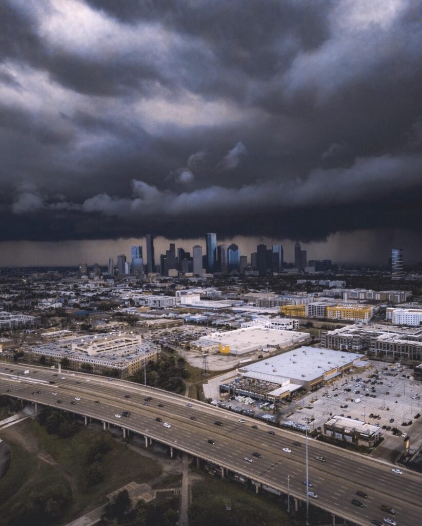 Houston skyline view with dark storm clouds approaching, emphasizing the urgency for houston hurricane season home prep and structural protection.